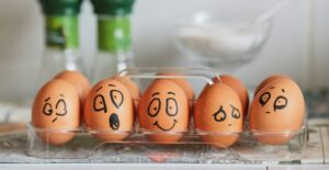 A photograph of eggs with faces drawn on them showing different emotions