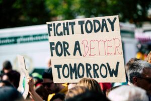 Photograph of a climate protest focused in on a sign that reads “Fight today for a better tomorrow.”